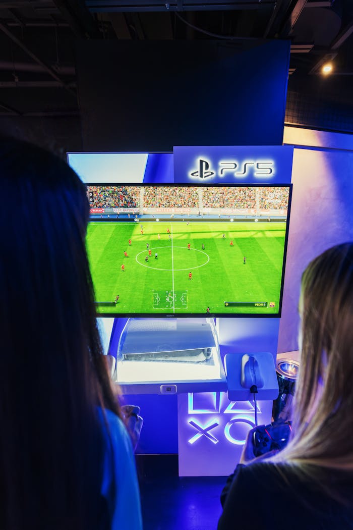 Two gamers playing FIFA on PS5 at a nighttime gaming event.